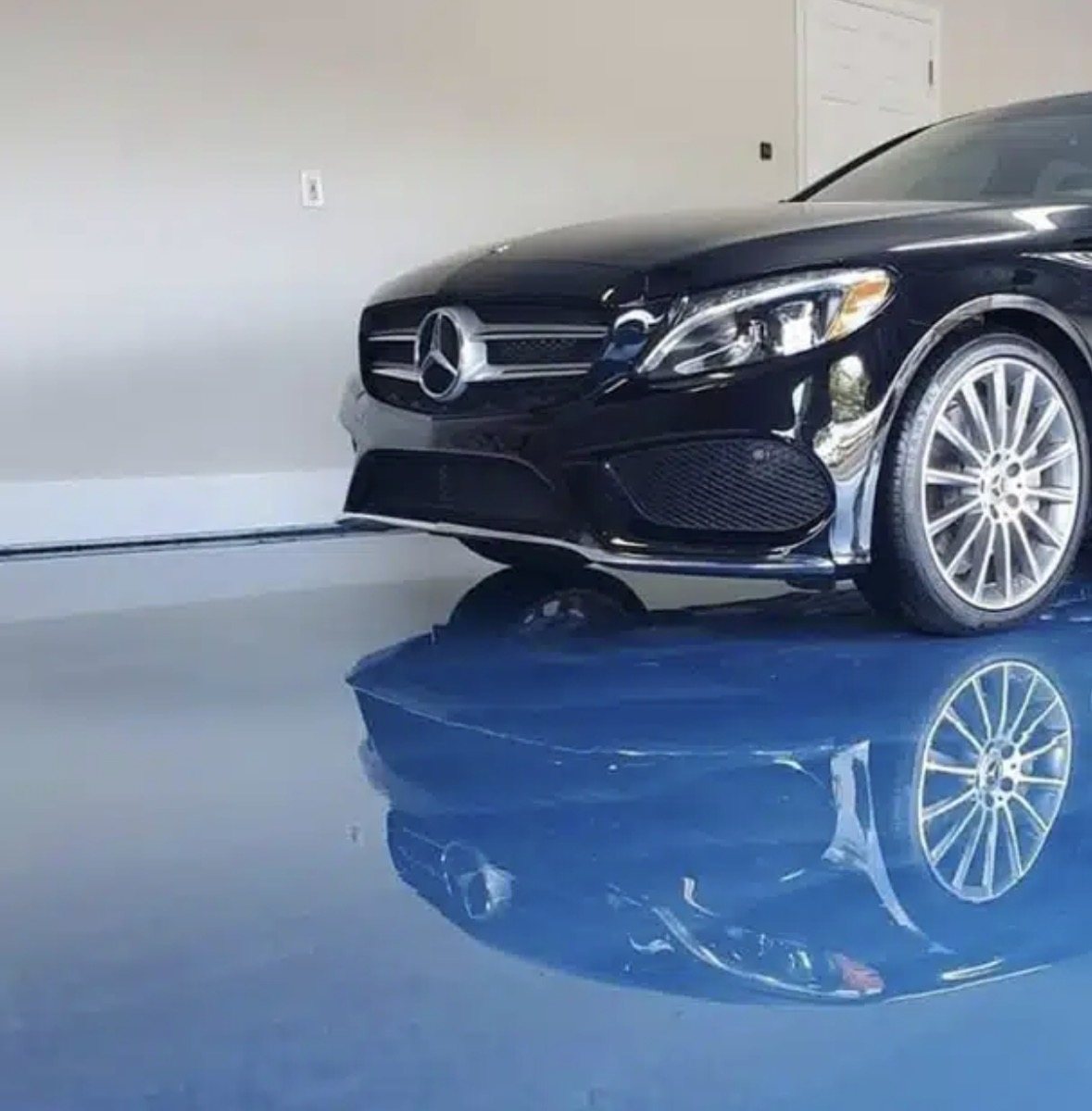 Glossy epoxy garage floor with black vehicle